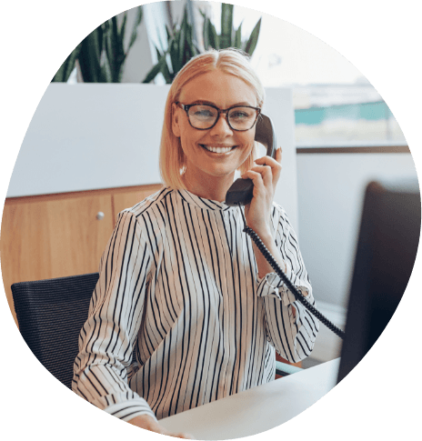 Woman at desk smiling while talking on phone