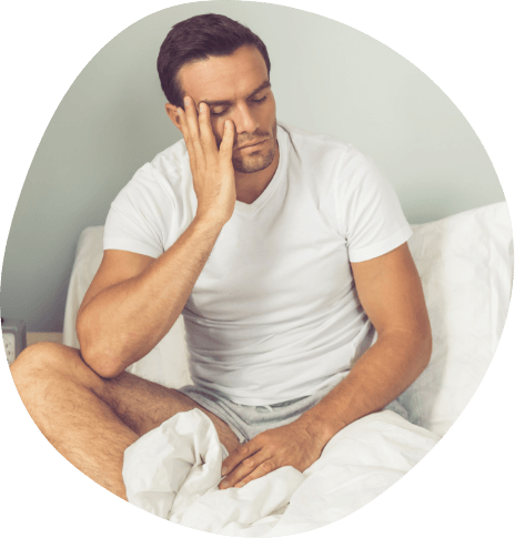 Man sitting awake in bed resting his chin in his hand
